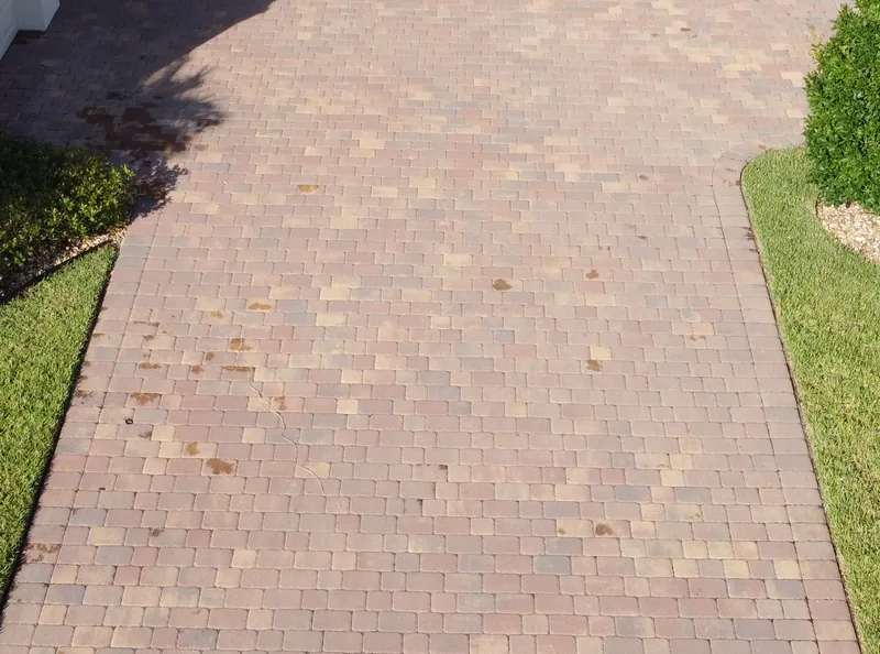 Paver driveway between lawn edges, viewed earlier that day