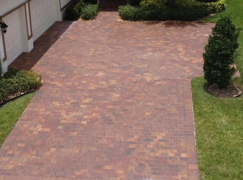 Paver driveway beside a garage and planting, photographed later that day
