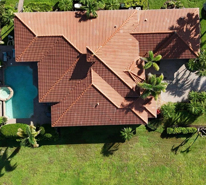 Finished tile roof viewed from above, with surrounding landscaping